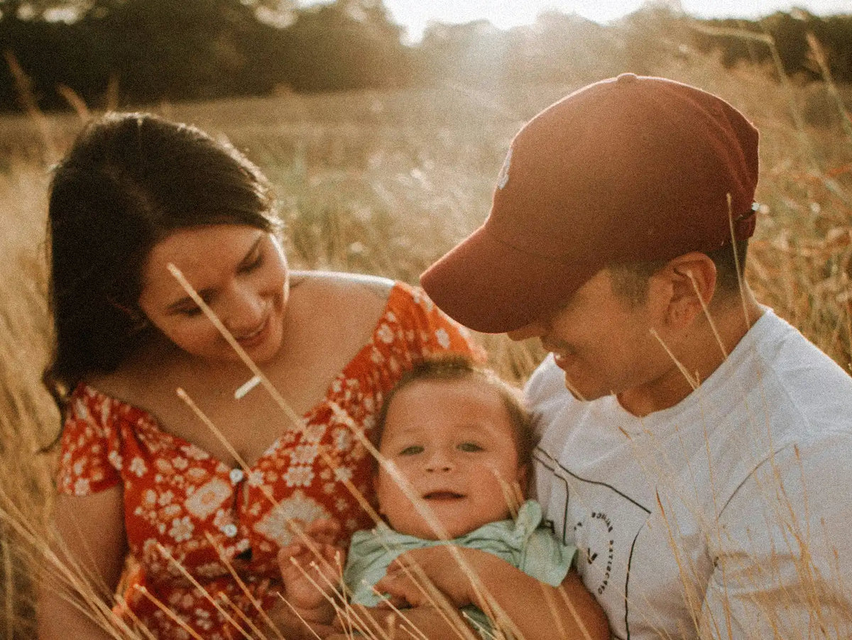 Famille souriante avec un bébé représentant l'importance des Oméga 3 DHA pour le bon développement du cerveau, de la vision et de la grossesse