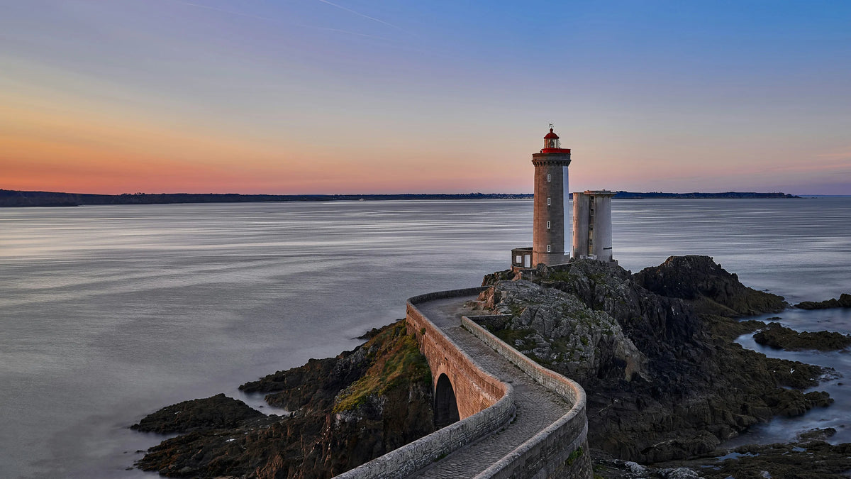 Phare breton au lever du soleil face à l’océan, illustrant l’histoire et la vision de Thaléïs Océan. Une image symbolisant notre ancrage en Bretagne, notre lien avec le monde marin et notre conviction : les réponses sont dans l’océan.