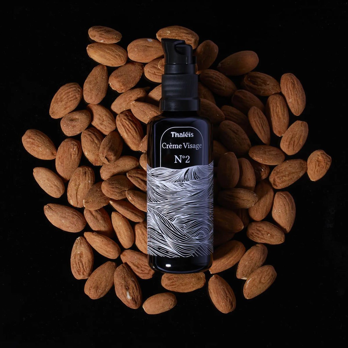 Photo de la crème visage N°2 sur un lit d'amande représentant le pouvoir hydratant et doux de l'huile d'amande douce présent dans notre crème.